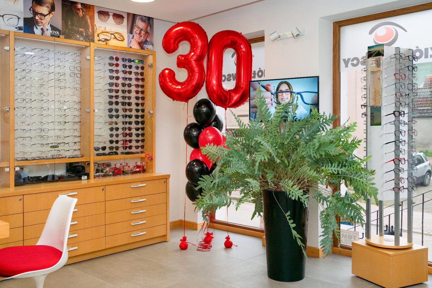 Wnętrze salonu w Trzebiatowie z balonami 30 lat i ekspozycją oprawek