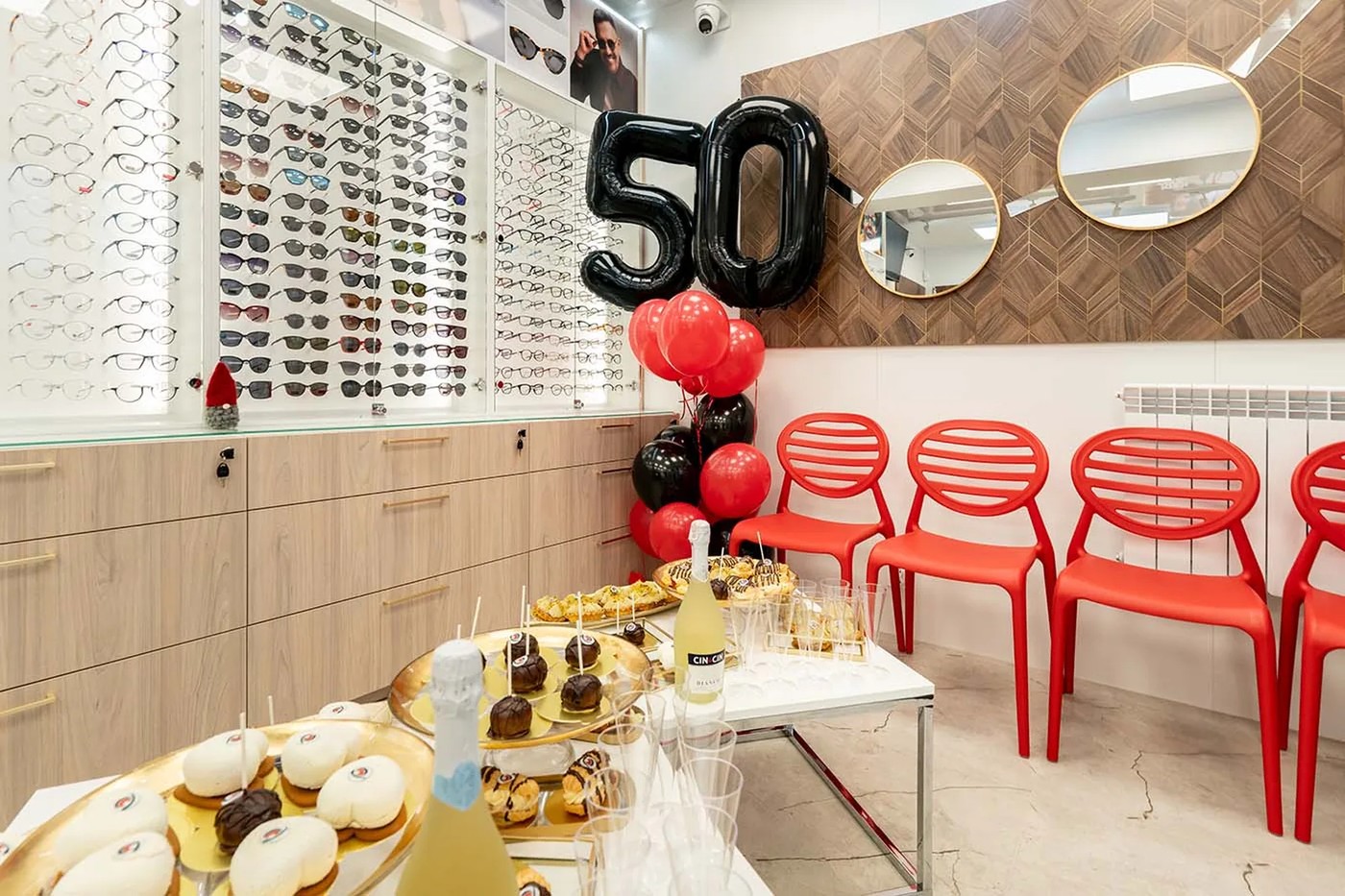 Poczekalnia z czerwonymi krzesłami i dekoracja 50 lat w salonie w Gryficach